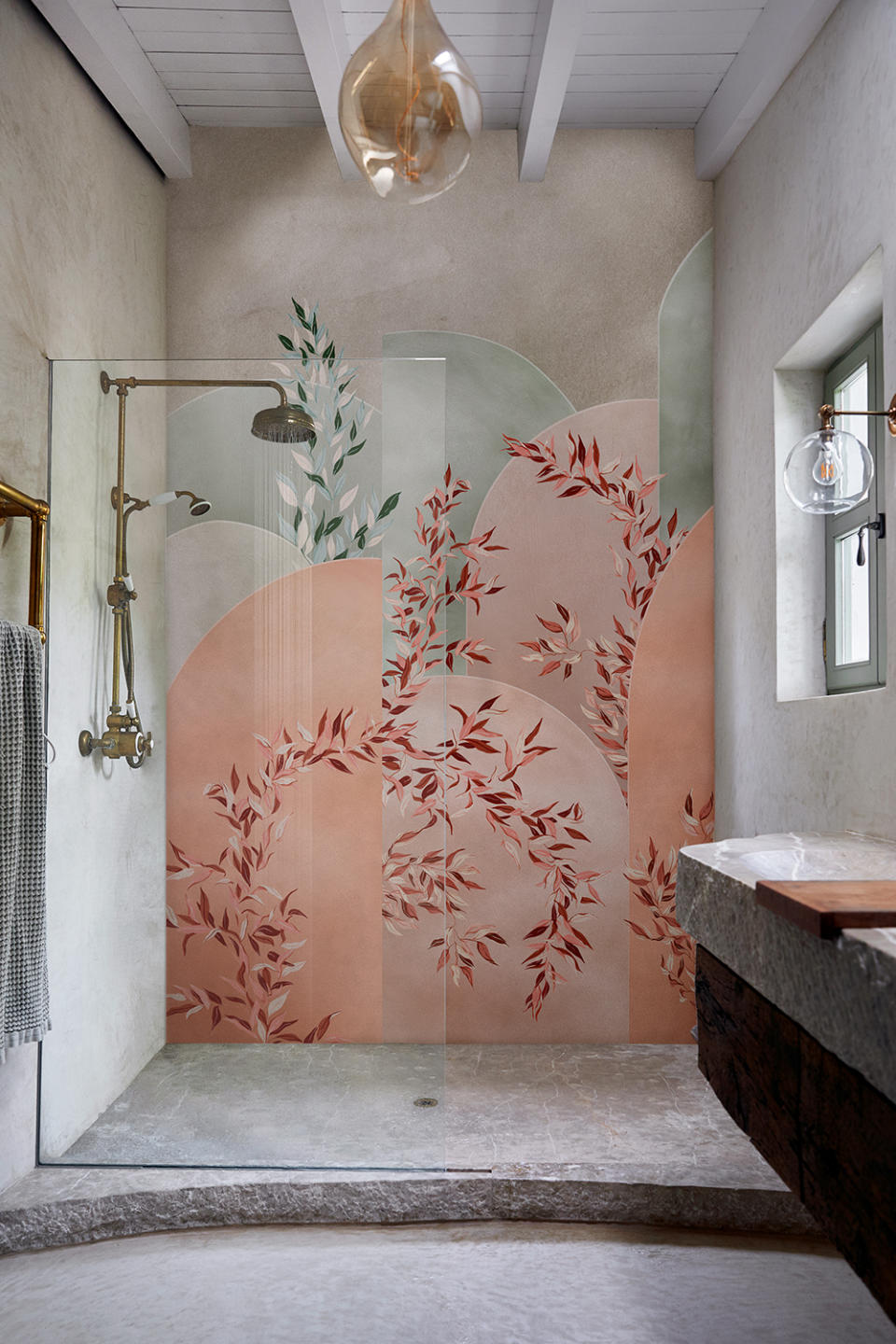 A shower with green and pink blossom print wallpaper in a stone scheme.