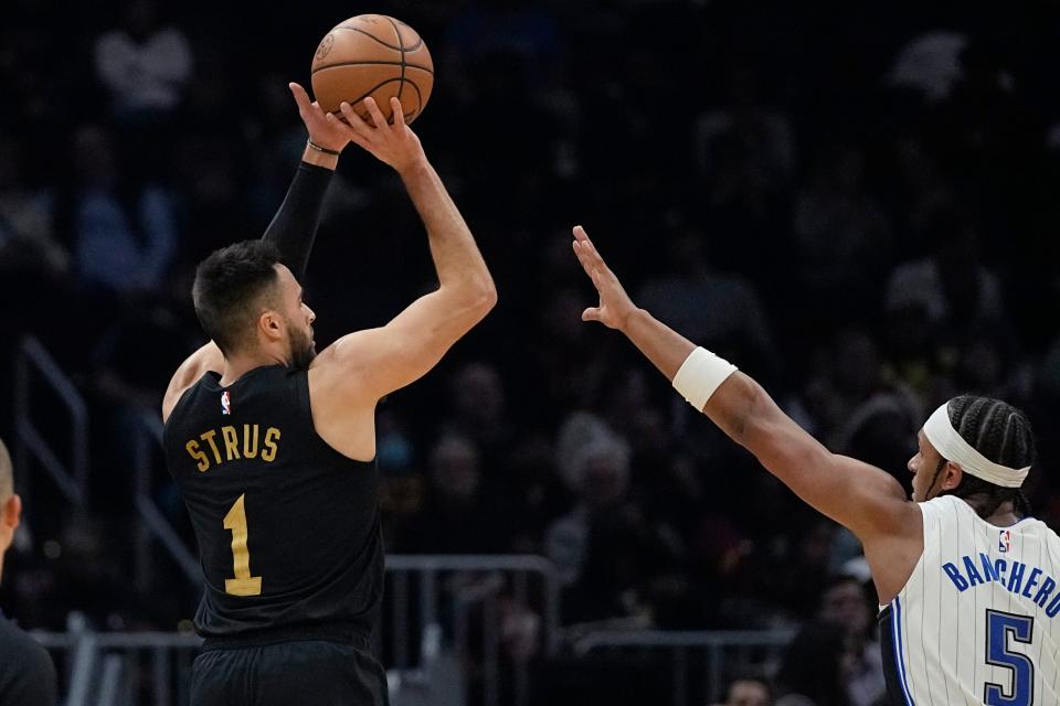 Cleveland Cavaliers guard Max Strus (1) shoots over Orlando Magic forward Paolo Banchero (5) during the first half of an NBA basketball game Wednesday, Dec. 6, 2023, in Cleveland. (AP Photo/Sue Ogrocki)