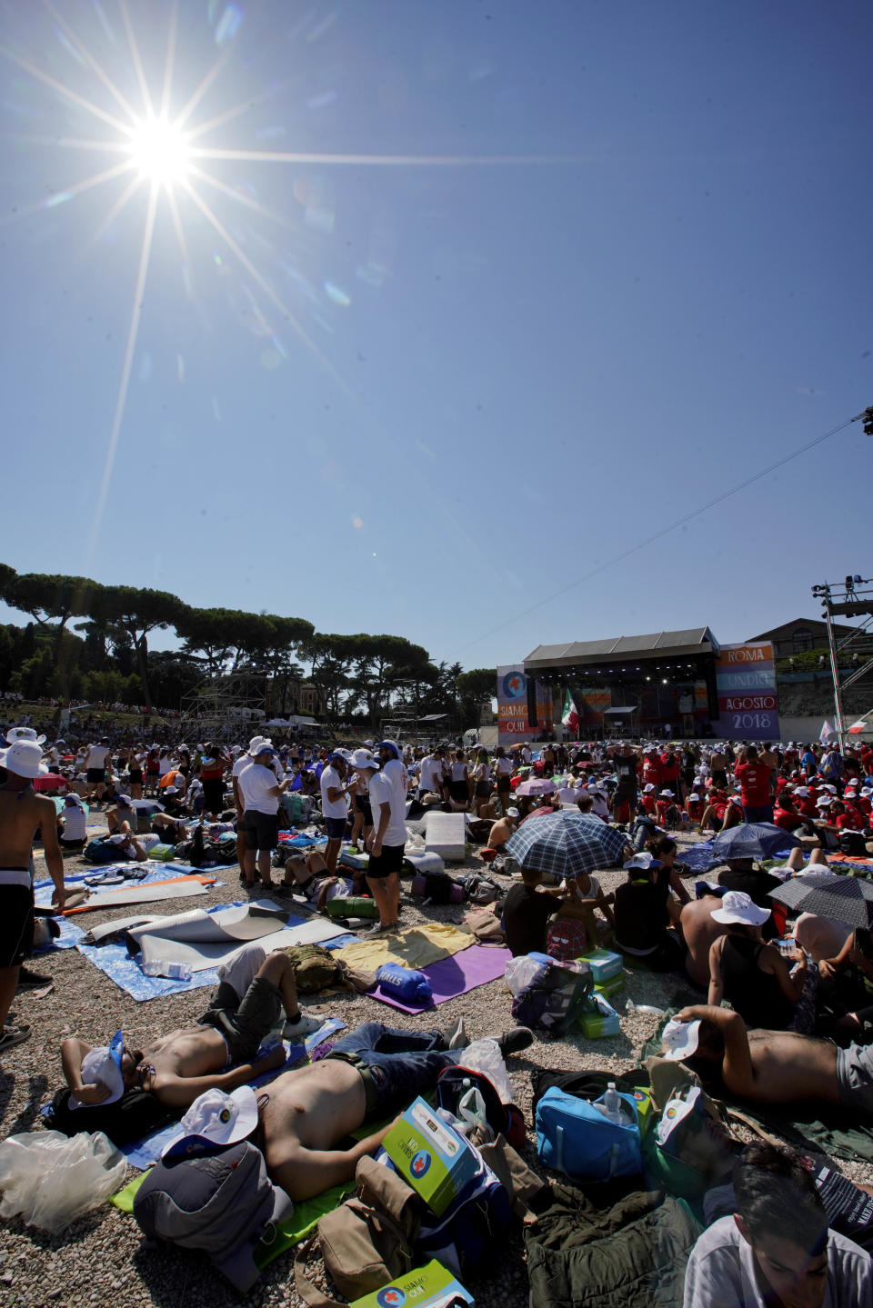 Faithful gather in Rome's Circus Maximus as they wait for the arrival of Pope Francis to lead an evening prayer vigil with youths, Saturday, Aug. 11, 2018. Thousand of youths gathered for the meeting with the pontiff in preparation for the next World Youth Day that will be held in Panama next year. (AP Photo/Andrew Medichini)