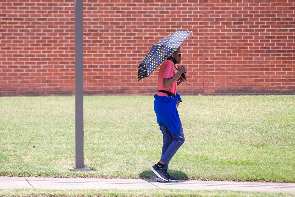 Norma Hicks walks down Linden Avenue with an umbrella to protect herself from the sun in Memphis, Tenn., on Thursday, June 29, 2023. The National Weather Service has said Memphis could have heat indexes close to 115 degrees on Thursday and Friday.
