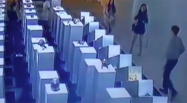 A gallery attendant (bottom right) comes rushing out to see what has happened. Picture: YouTube