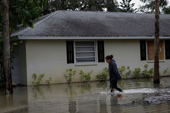 A woman walks in flooded driveway after Hurricane Nicole's landfall, in Vero Beach, Florida, on November 10, 2022. - Tropical Storm Nicole slowed after making landfall in the US state of Florida, meteorologists said Thursday. (Photo by Eva Marie UZCATEGUI / AFP) (Photo by EVA MARIE UZCATEGUI/AFP via Getty Images)
