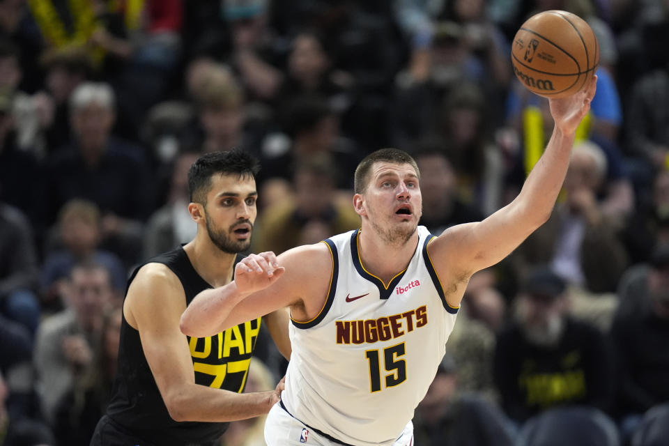 Denver Nuggets center Nikola Jokic (15) catches a pass as Utah Jazz center Omer Yurtseven (77) defends during the second half of an NBA basketball game Tuesday, April 9, 2024, in Salt Lake City. (AP Photo/Rick Bowmer)