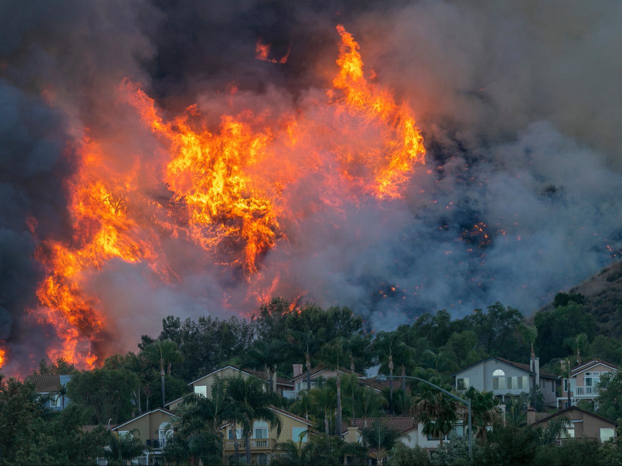 Flames rise near homes during the Blue Ridge wildfire on October 27, 2020 in Chino Hills, California. A new poll has found that the majority of Americans think we are running out of time to save the planet from the climate crisis (Getty Images)