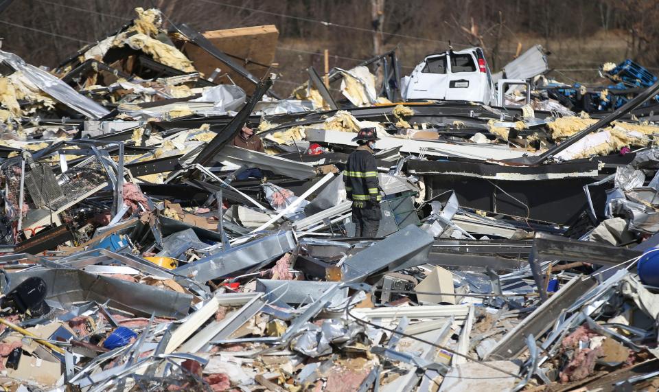 Rescue teams search for people among the remains of a candle factory in Mayfield, Ky., after a deadly tornado ripped through the small community.