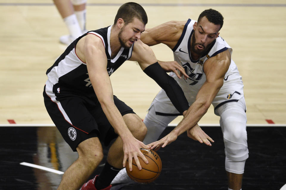 Los Angeles Clippers center Ivica Zubac, left, attempts to drive the ball to the basket while pressured by Utah Jazz center Rudy Gobert during the first half of an NBA basketball game in Los Angeles, Friday, Feb. 19, 2021. (AP Photo/Kelvin Kuo)
