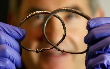 Silver arm-rings are held by metal-detectorist, James Mather, who discovered a Viking Hoard, which also included silver ingots and rare coins of King Alfred of Wessex and King Ceolwulf II of Mercia, at the British Museum London Britain December 10, 2015. REUTERS/Peter Nicholls