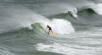 <p>A surfer rides a wave near the Okaloosa Island Fishing Pier near Fort Walton Beach, Fla. on June 20, 2017. Tropical Storm Cindy churned up the Gulf of Mexico, causing high surf and heavy winds along coastal northwest Florida. (Photo: Devon Ravine/Northwest Florida Daily News via AP) </p>