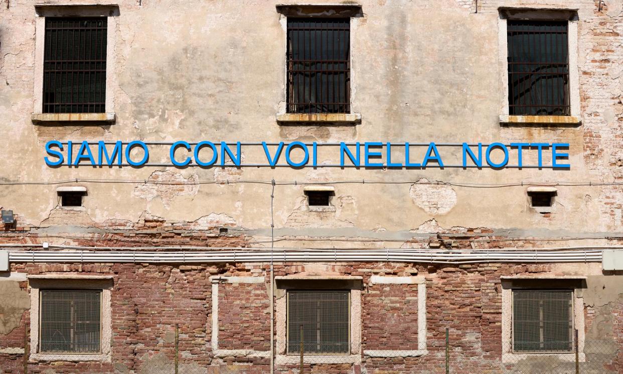 <span>Slogan that translates as ‘we are with you in the night’ on a wall at Giudecca women’s prison in Venice, part of the Biennale installation.</span><span>Photograph: David Levene/The Guardian</span>