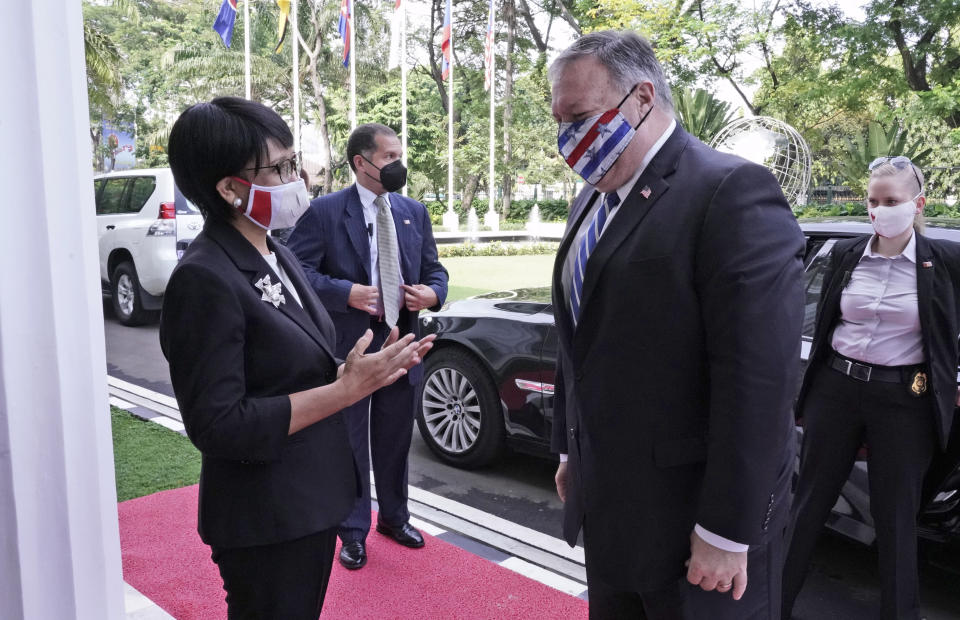 In this photo released by Indonesian Ministry of Foreign Affairs, Indonesian Foreign Minister Retno Marsudi, left, talks to U.S. Secretary of State Mike Pompeo, right, upon his arrival for their meeting in Jakarta, Indonesia, Thursday, Oct. 29, 2020. Pompeo renewed the Trump administration's rhetorical onslaught against China in Indonesia on Thursday as the American presidential election looms. (Indonesian Ministry of Foreign Affairs via AP)