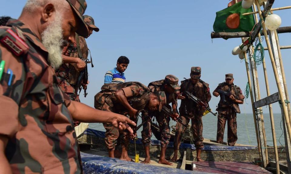 Bangladesh border guards search a fishing boat for drugs as part of the crackdown on the narcotics trade that has left 50 dead in one week. 