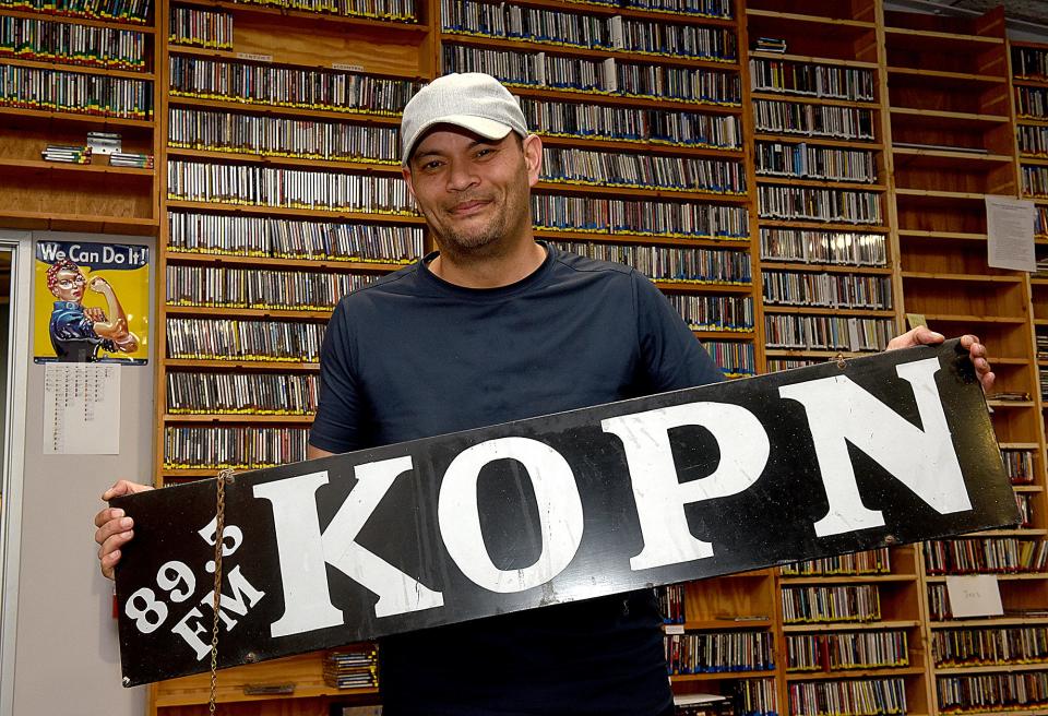 KOPN 89.5 FM Executive Director Jet Ainsworth poses with an old KOPN sign in the new KOPN music library at 401 Bernadette Drive. The local community radio station is known for its diverse talk and music has been broadcasting in Missouri since 1973.