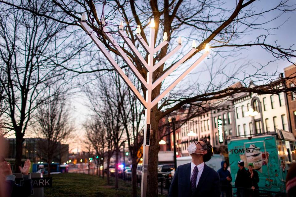 Rabbi David Wirtschafter looked up after lighting the menorah at the holiday festival Sunday night.