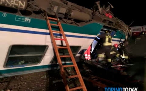 Firemen and rescue personnel get to a train that plowed into a big-rig truck that was on the tracks - Credit: AP