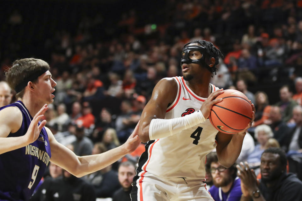 Oregon State guard Dexter Akanno (4) looks to pass around Washington guard Nate Calmese (8) during the first half of an NCAA college basketball game Saturday, Feb. 10, 2024, in Corvallis, Ore. (AP Photo/Amanda Loman)