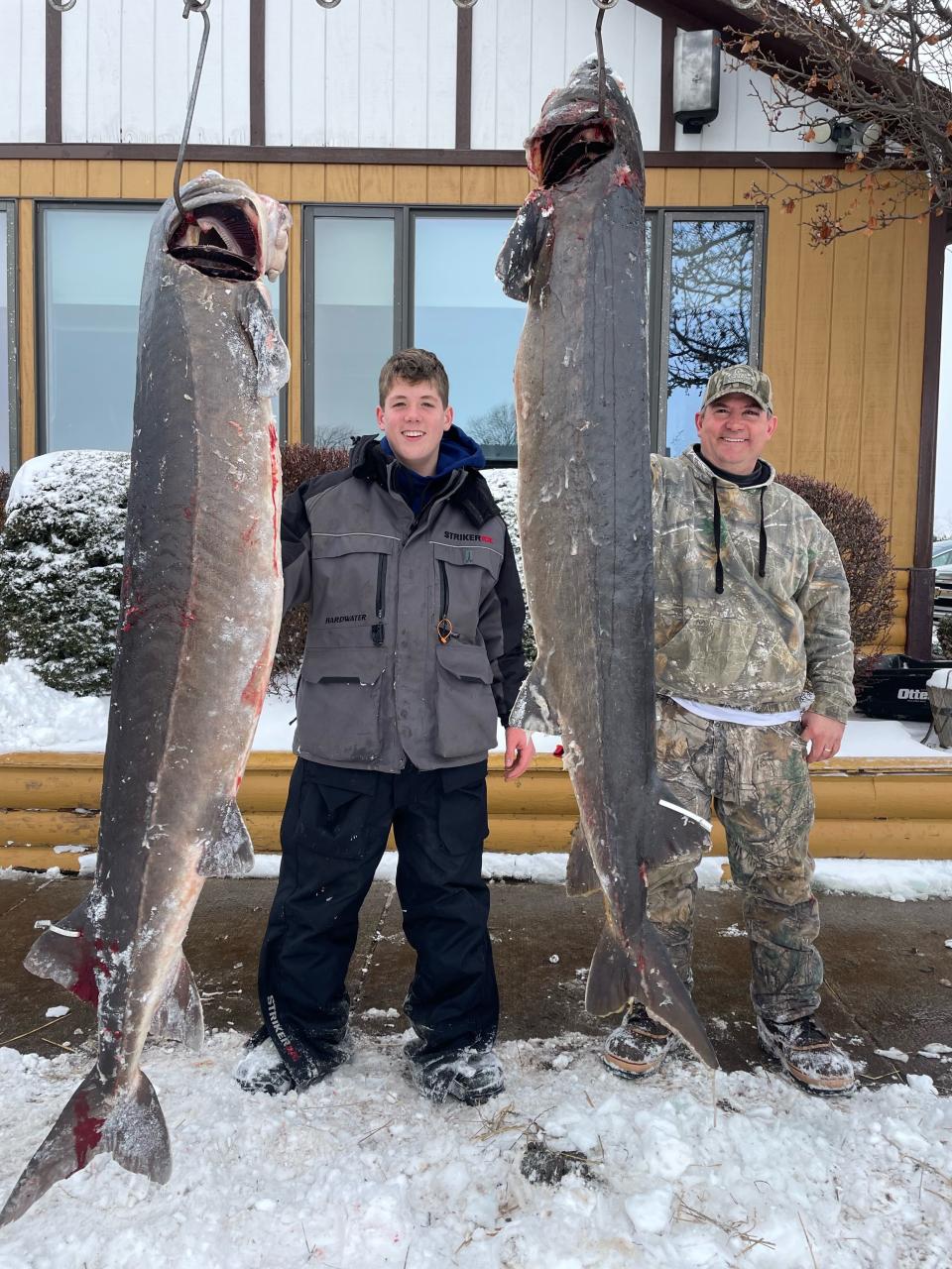 Eli (left) and his father Paul Muche, both of Van Dyne, pose with lake sturgeon they speared hours apart Feb. 23 in the same shack on Lake Winnebago. Eli's fish weighed 111 pounds and Paul's weighed 91.