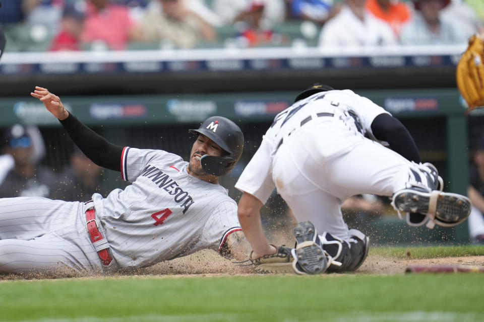 Minnesota Twins' Carlos Correa (4) slides safely into home plate ahead of the tag of Detroit Tigers catcher Jake Rogers in the 10th inning of a baseball game, Sunday, June 25, 2023, in Detroit. (AP Photo/Paul Sancya)