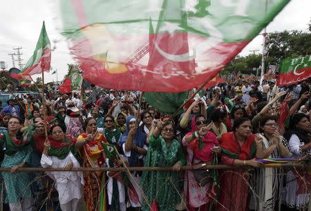 Supporters of Imran Khan, cricketer-turned-opposition politician and chairman of the Pakistan Tehreek-e-Insaf (PTI) political party, wave flags upon their arrival to attend the Freedom March in Islamabad August 16, 2014. REUTERS/Faisal Mahmood