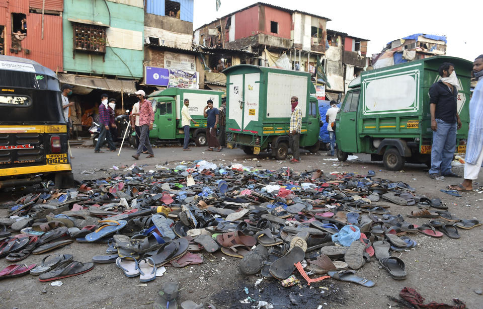 In this Tuesday, April 14, 2020, photo, shoes of migrant workers lie in piles on a road, left behind after police chased them away during a protest against the extension of the lockdown in a slum in Mumbai, India. Tens of thousands of impoverished migrant workers are on the move across India, walking on highways and railway tracks or riding trucks, buses and crowded trains in blazing heat amid threat to their lives from the coronavirus pandemic. (AP Photo)