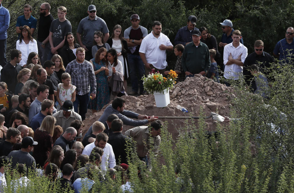 Family and friends gather for the burial service for Dawna Ray Langford, 43, and her sons Trevor, 11, and Rogan, 2, who were killed in an ambush earlier this week, at a small cemetery in La Mora, Mexico, Thursday, Nov. 7, 2019. As Mexican soldiers stood guard, the three were laid to rest in a single grave at the first funeral for the victims of a drug cartel ambush that left nine American women and children dead. (AP Photo/Marco Ugarte)