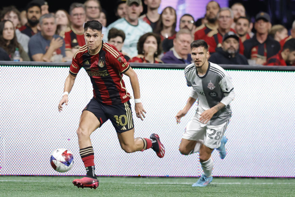 Atlanta United midfielder Luiz Araújo, left, drives past Toronto FC defender Raoul Petretta, right, during the second half of an MLS soccer match, Saturday, March 4, 2023, in Atlanta. (AP Photo/Alex Slitz)