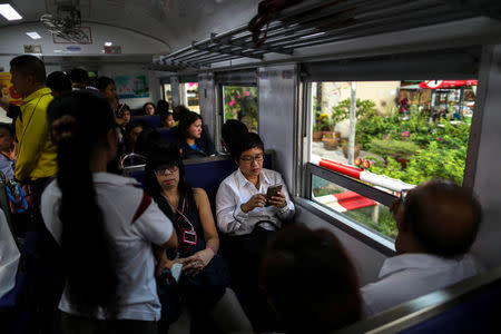 Boodsabann Chanthawong, 49, a businesswoman, works on her mobile phone as she rides on a train, weeks ahead of her ordination to be a novice monk in Bangkok, Thailand, November 22, 2018. REUTERS/Athit Perawongmetha