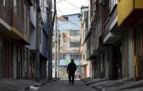 Un hombre camina por una calle desierta de Bogotá el 5 de agosto del 2020. Cuatro meses después de surgido el brote de coronavirus, Colombia mantiene una cuarentena que cada vez abruma más a la gente. (AP Photo/Fernando Vergara)