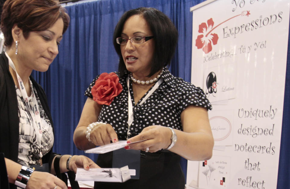 Businesswoman Ivette Mayo, right, of Houston, talks to a customer at the U.S. Hispanic Chamber of Commerce (USHCC) 32nd annual Convention and Business Expo in Miami Beach, Fla., Tuesday Sept. 20, 2011. The growth of Hispanic-owned businesses is three times higher than any other population group, and four times higher for business owned by Hispanic women, according to the USHCC. (AP Photo/Alan Diaz)