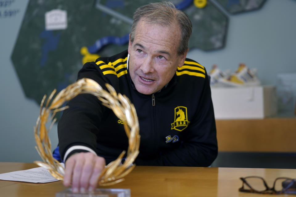 Boston Athletic Association President and CEO Jack Fleming displays a marathon trophy while speaking with reporters Wednesday, March 22, 2023, in Boston. In all, about 30,000 people head to Hopkinton, Mass., on the third Monday in April. Since the bombings, the field has included many who were not marathoners, or even runners, but were compelled to enter as part of the healing process. "The course is the same," said Fleming, who runs the organization that runs the marathon. "The journeys are very different." (AP Photo/Steven Senne)