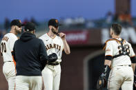 San Francisco Giants starter Alex Wood, center, talks to teammates Buster Posey (28) and Evan Longoria (10) and pitching coach Andrew Bailey, second from left, before pitching against the Texas Rangers during the sixth inning of a baseball game in San Francisco, Monday, May 10, 2021. (AP Photo/John Hefti)