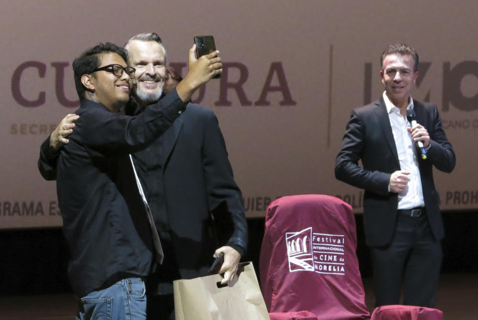 El cantante y actor español Miguel Bosé, segundo de izquierda a derecha, se toma una selfie con un fan durante una charla sobre la película "Tacones lejanos" en el Festival Internacional de Cine de Morelia en Morelia, México, el lunes 23 de octubre de 2023. (Foto AP/Berenice Bautista)