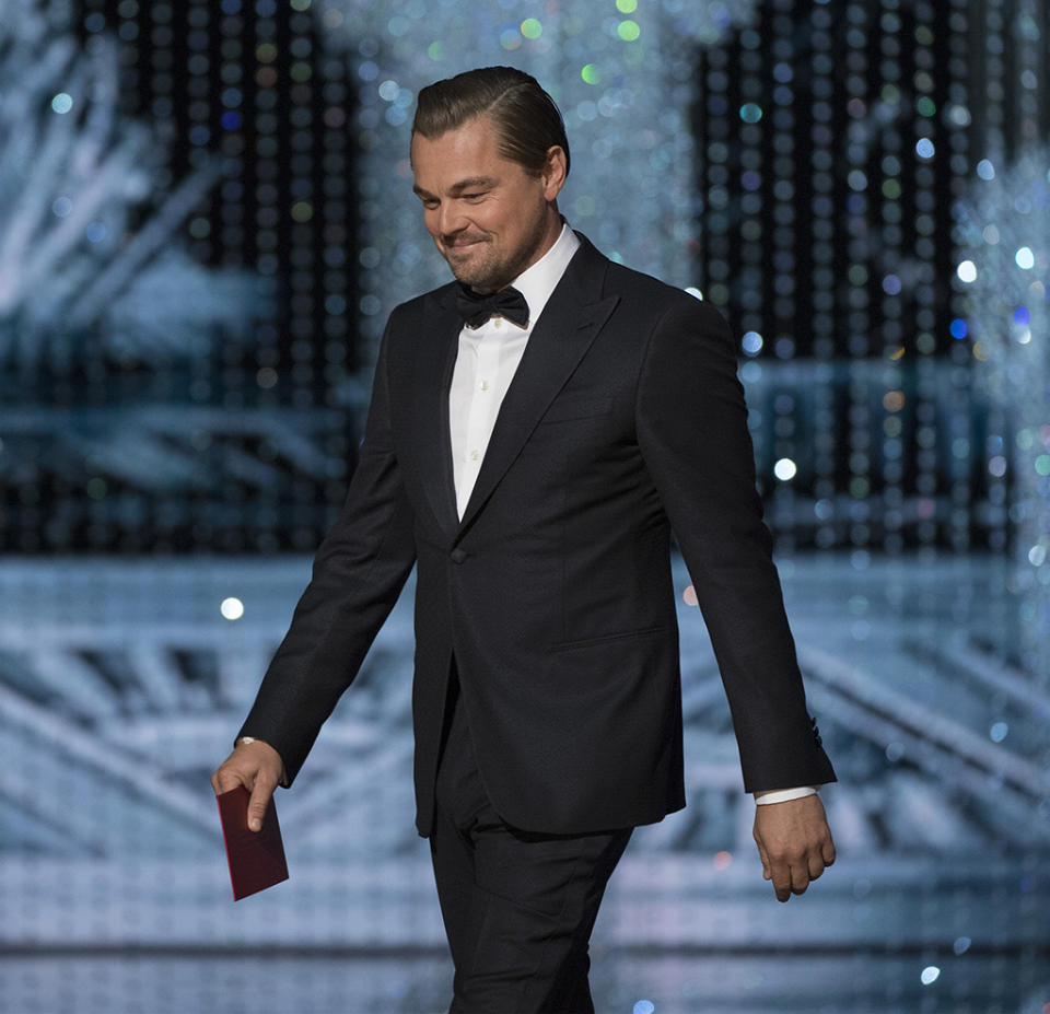 Leo walking across the stage at the 2017 Oscars