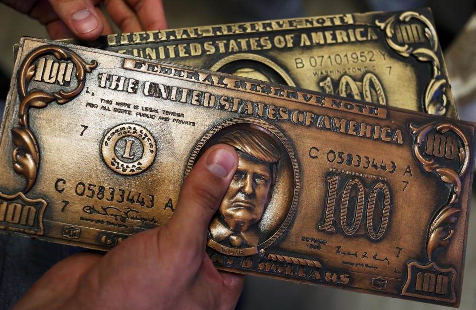 A mock money printing plate with US President Donald Trump face in place of Benjamin Franklin. (AP Photo/Pavel Golovkin)