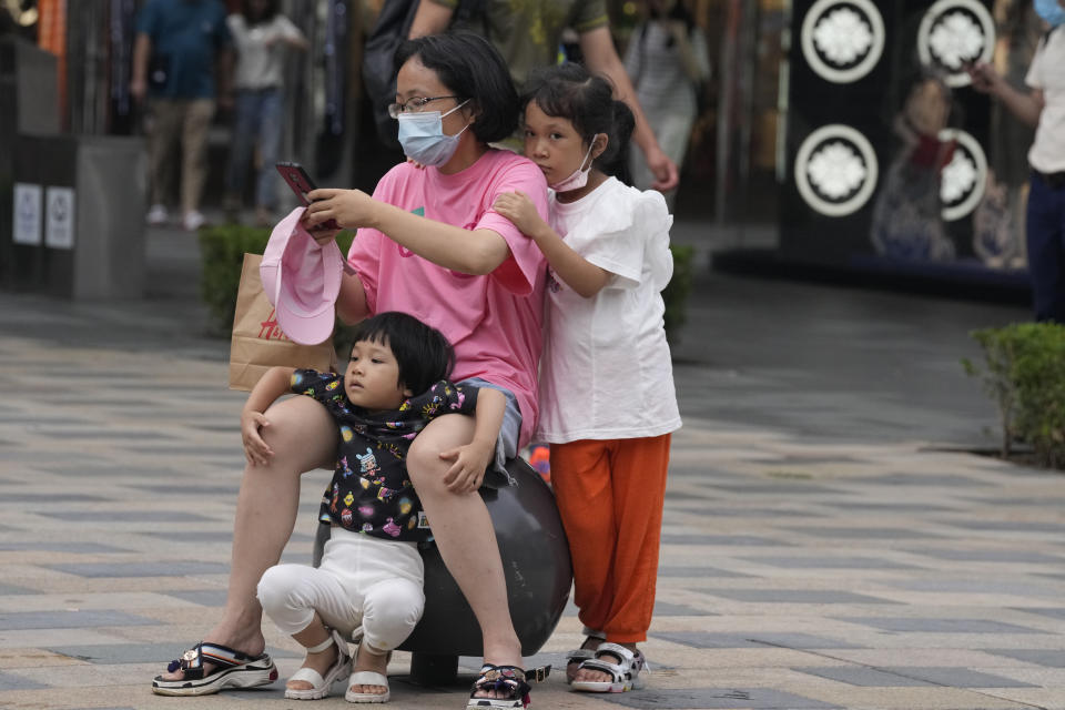 A woman looks at her smartphone at a mall in Beijing, Monday, July 5, 2021. Days after China's largest ride-hailing app Didi Global Inc. went public in New York as the biggest Chinese IPO in the U.S. since Alibaba's 2014 listing, Chinese regulators clamped down on the firm, ordering it to halt new registrations and remove its app from China's app stores while the company undergoes a cybersecurity review. (AP Photo/Ng Han Guan)