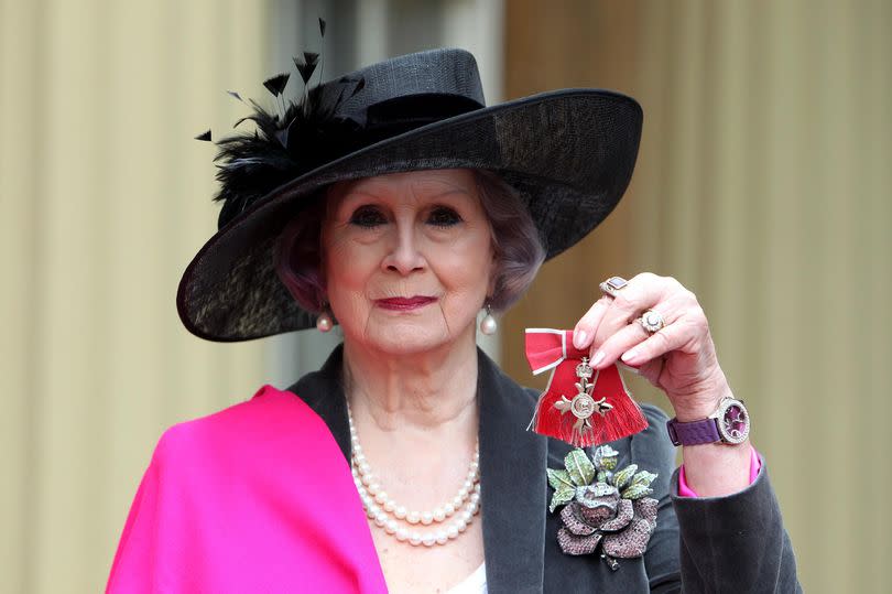 April Ashley poses with her Member of the British Empire medal