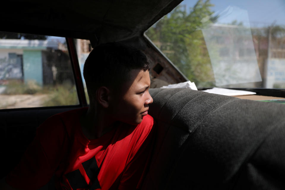 Baseball little league player Ibrahim Ruiz, 13, sits in his father's car as they drive to fill fuel in Maracaibo, Venezuela. (Photo: Manaure Quintero/Reuters)