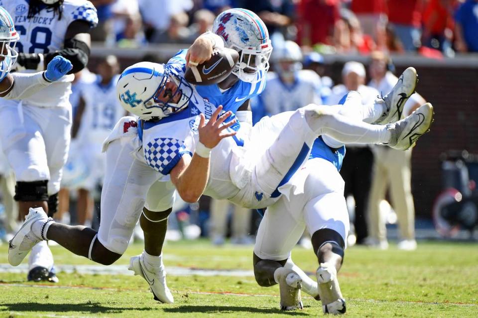 Mississippi’s AJ Finley (21) and Austin Keys (11) force a key fumble from Kentucky quarterback Will Levis (7) late in the second half Saturday. The play was the subject of a debate as to whether an Ole Miss defender should have been penalized for targeting.