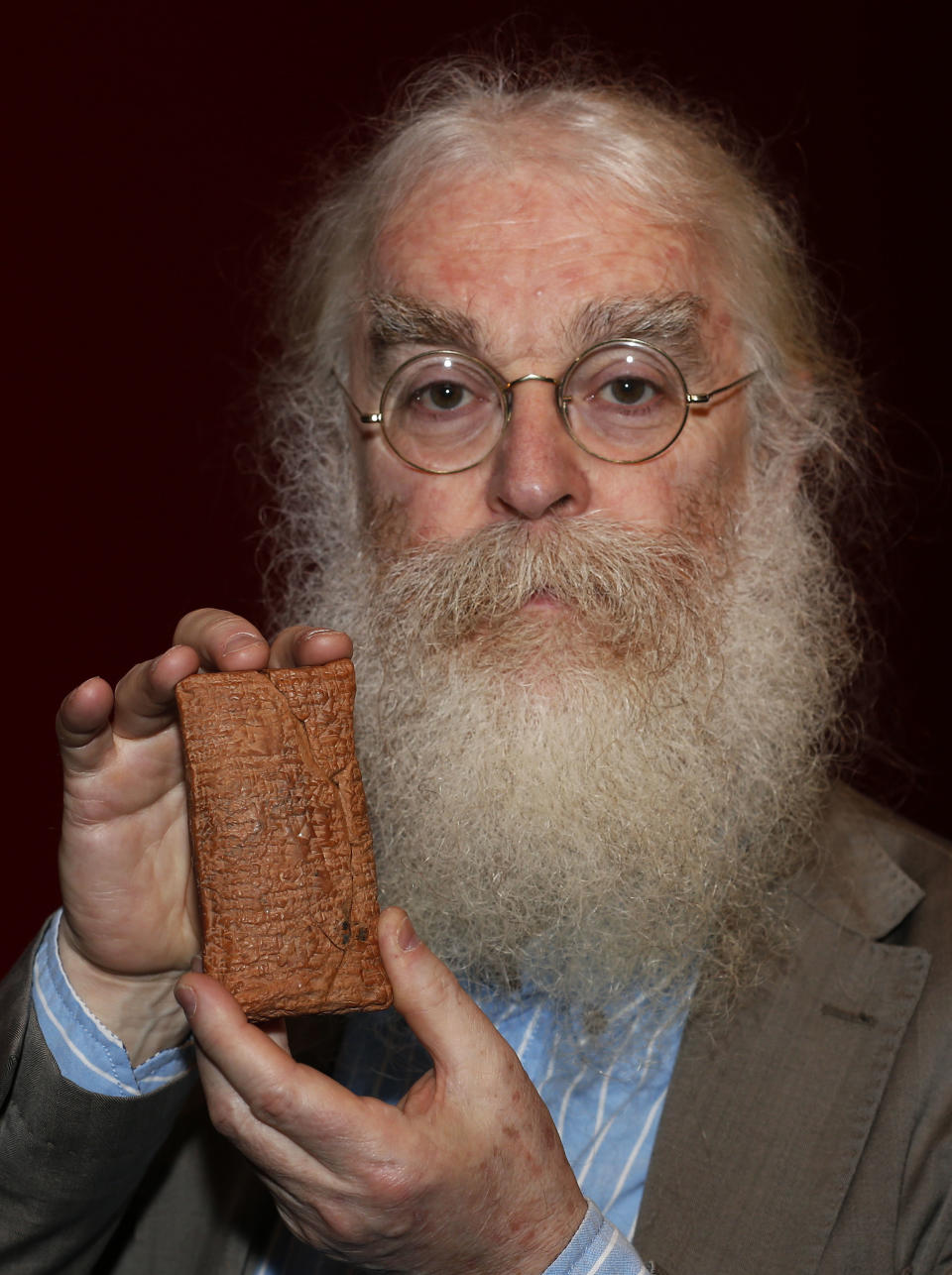 Irving Finkel, curator in charge of cuneiform clay tablets at the British Museum, poses with the 4000 year old clay tablet containing the story of the Ark and the flood during the launch of his book 'The Ark Before Noah' at the British Museum in London, Friday Jan. 24, 2014. The book tells how he decoded the story of the Flood and offers a new understanding of the Old Testament's central narratives and how the flood story entered into it. (AP Photo/Sang Tan)