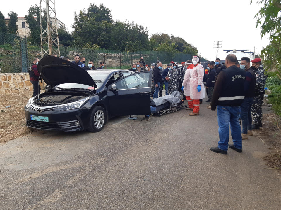 Security forces inspect the scene where Lokman Slim, a longtime Shiite political activist and researcher, was found found dead in his car in Addoussieh village, in the southern province of Nabatiyeh, Lebanon, Thursday, Feb. 4, 2021. (AP Photo/Mohammed Zaatari)