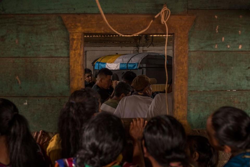 Relatives and friends during the burial of Marcos Abdón Tziquin Cuc, 21, in the village of Paquilá, Guatemala, on April 13. The remains of 17 Guatemalans were flown home after they were killed by a fire in March at a migration center in Ciudad Juárez, Mexico, near the border with Texas, that left a total of 40 people dead.<span class="copyright">Daniele Volpe—The New York Times/Redux</span>