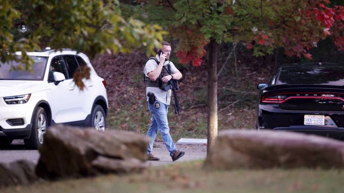 A law enforcement officer walks at the entrance to Neuse River Greenway Trail parking following a shooting in Raleigh, North Carolina, on Oct. 13.