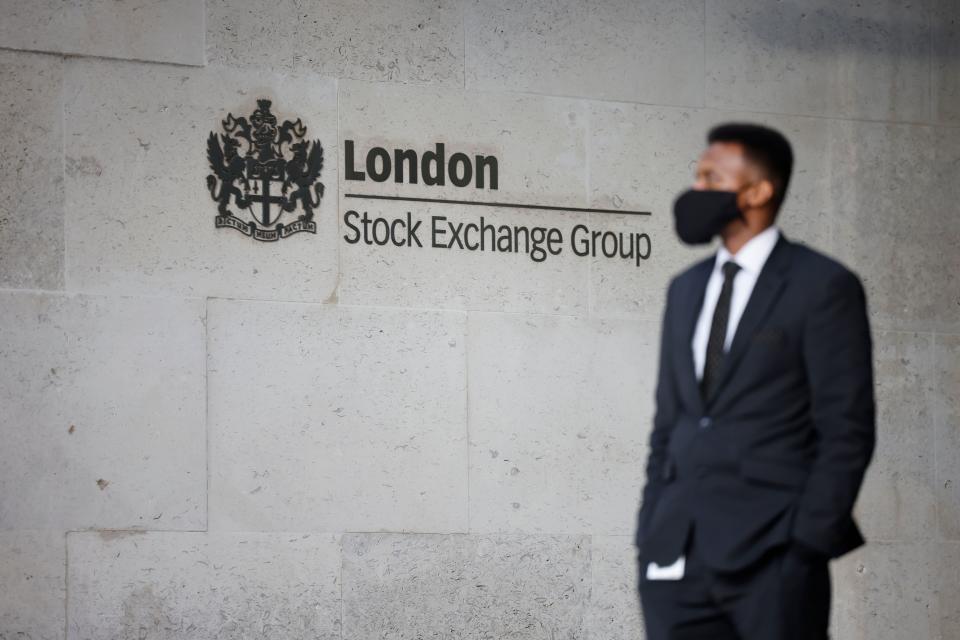 A security guard stands beside the logo for the London Stock Exchange Group outside the stock exchange in London on December 29, 2020. - The London stock market soared on December 29 as investors gave their initial verdict on Britain's Brexit deal with the EU, while eurozone equities also rose on upbeat US stimulus news, with Frankfurt extending its record breaking run. (Photo by Tolga Akmen / AFP) (Photo by TOLGA AKMEN/AFP via Getty Images)