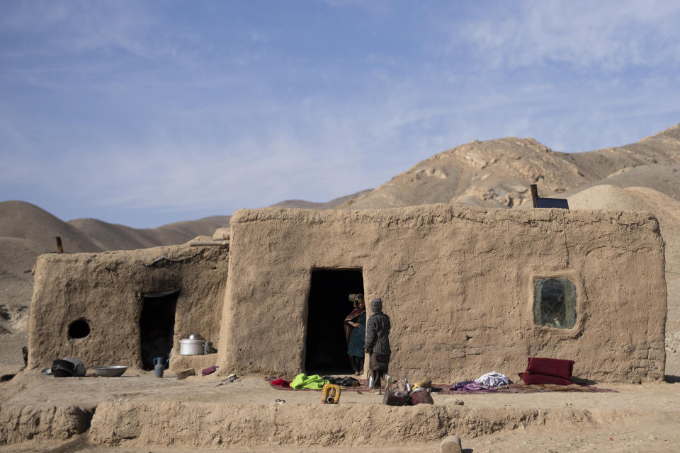 The granddaughter of Hajji Wali Jan, 66, stands at the entrance of her house in Kamar Kalagh village outside Herat, Afghanistan, Friday, Nov. 26, 2021. Afghanistan’s drought, its worst in decades, is now entering its second year, exacerbated by climate change. (AP Photo/Petros Giannakouris)