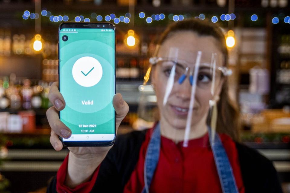 Anabela Monteiro at The Belmont Bar and Bistro in Belfast holds a customer’s scanned digital Health & Social Care Northern Ireland (HSC NI) Covid certificate (Liam McBurney/PA) (PA Wire)