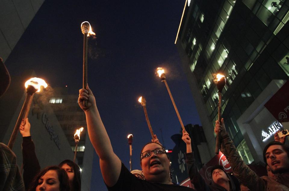 Demonstrators yell slogans while carrying torches during a protest in support of 43 missing Ayotzinapa students, in Monterrey