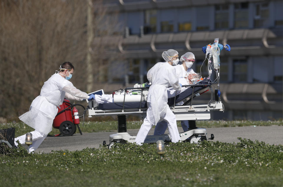FILE - In this photo taken Monday March 23, 2020, a victim of the Covid-19 virus is evacuated from the Mulhouse civil hospital, eastern France. The Grand Est region is now the epicenter of the outbreak in France, which has buried the third most virus victims in Europe, after Italy and Spain. For most people, the new coronavirus causes only mild or moderate symptoms. For some it can cause more severe illness. (AP Photo/Jean-Francois Badias, File)