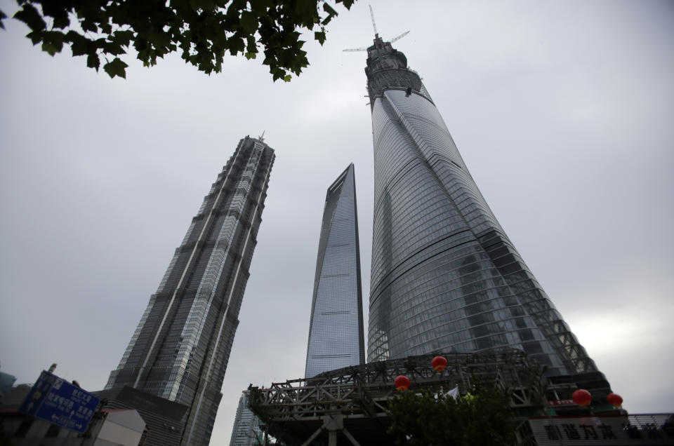 The Shanghai Tower, right, is seen among other skyscrapers prior to the topping off ceremony in Shanghai, China, Saturday, Aug. 3, 2013. The Shanghai Tower is set to become the tallest building in China which is planned to be complete in 2014. (AP Photo/Eugene Hoshiko)