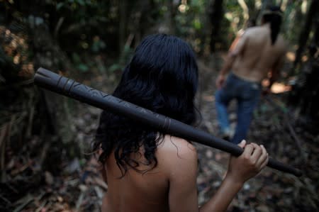 Indigenous people walk in a deforested area in nondemarcated indigenous land inside the Amazon rainforest near Humaita
