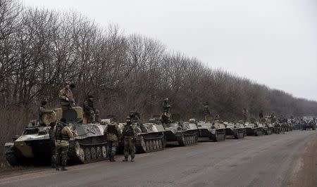 Members of the Ukrainian armed forces and armoured personnel carriers are seen preparing to move as they pull back from Debaltseve region, near Artemivsk February 26, 2015. REUTERS/Gleb Garanich