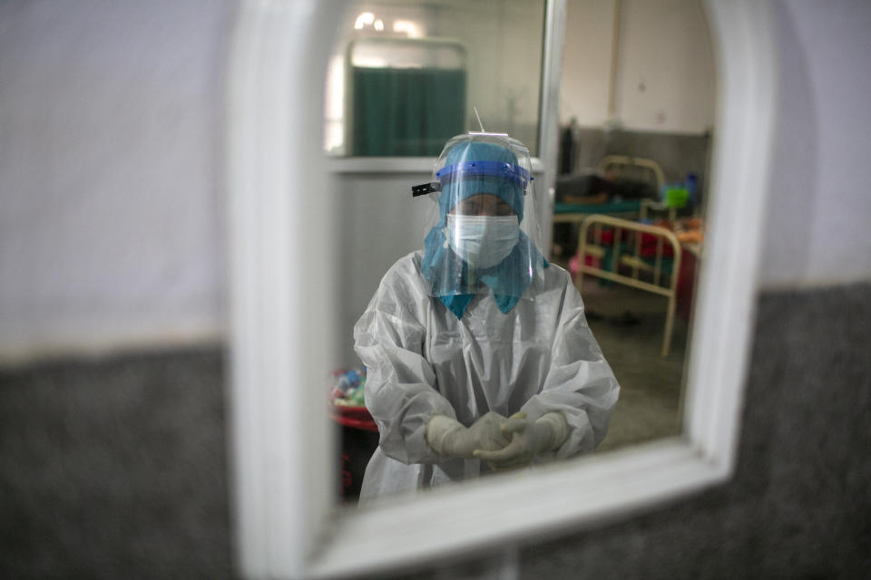 A nurse sanitizes her hands at a COVID-19 ward of a government run hospital in Kathmandu, Nepal, Wednesday, May 12, 2021. (AP Photo/Niranjan Shrestha)